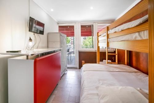 a bedroom with two bunk beds and a tv at Caparica Beach Charming in Costa da Caparica