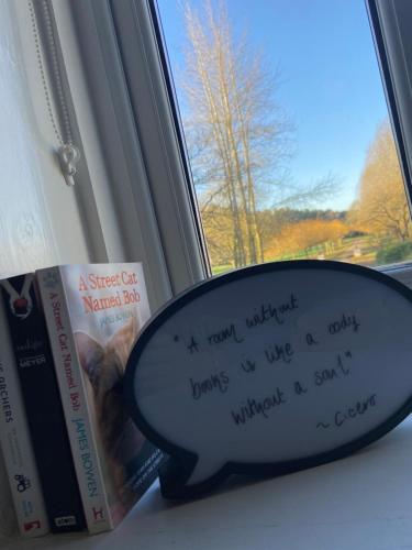 a magnifying glass sitting next to books on a window at Nettleton Country House in Nettleton