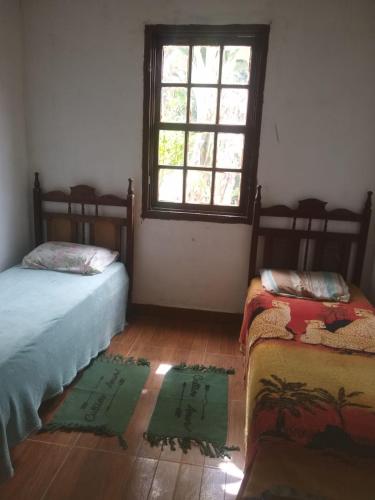 um quarto com duas camas e uma janela em Chácara lua e Sol em Pouso Alegre