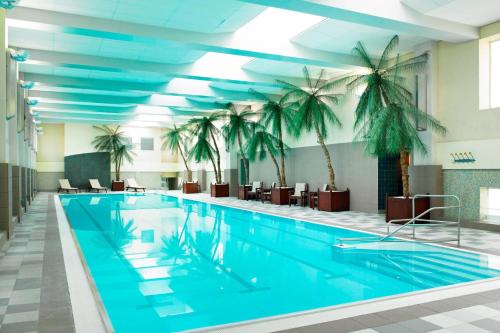 a pool with palm trees in a hotel room at London Marriott Hotel County Hall in London