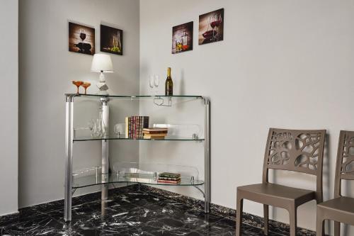 szklaną półkę z butelką wina i krzesłem w obiekcie Aurora casa vacanze w mieście Pozzallo