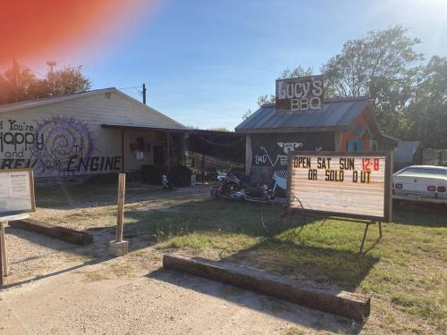 un edificio con una señal delante de él en Hippie Haus next to iconic BBQ restaurant, en Lakehills