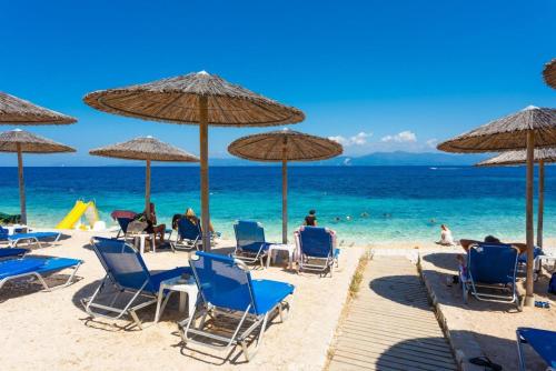 a beach with chairs and umbrellas and the ocean at Dimitris Cottage in Apergátika
