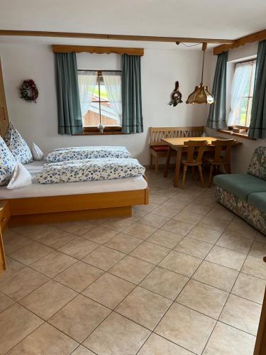 a bedroom with a bed and a table and chairs at Beim Hanslbauer in Reit im Winkl