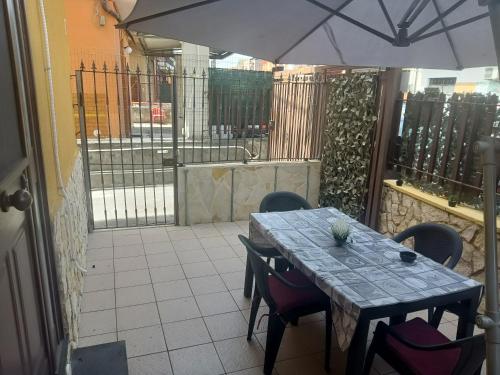 a table and chairs with an umbrella on a patio at Delilah's house in Catania