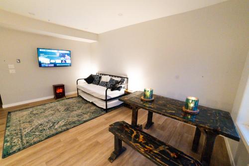 a living room with a couch and a table at Kid & Pet Friendly Walkout BSMT 90 mins to Banff and 30 mins to Downtown Calgary in Calgary