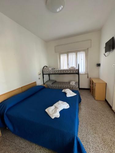 Un dormitorio con una cama azul con toallas. en Mehari Hotel Rimini en Rímini
