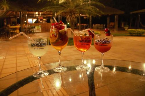 cuatro copas de vino sentadas sobre una mesa en Hotel Fazenda Cachoeiras Serra da Bodoquena en Bodoquena