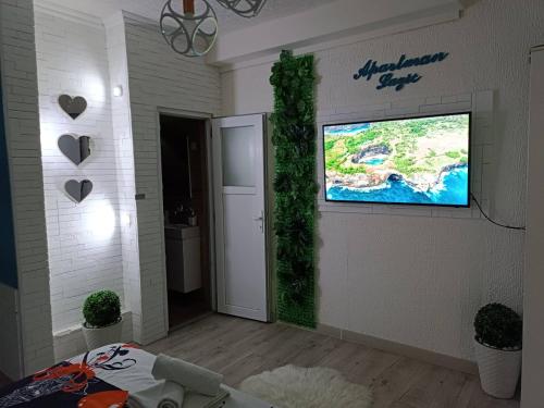 a living room with a flat screen tv on a wall at Apartman u centru 1 in Šid