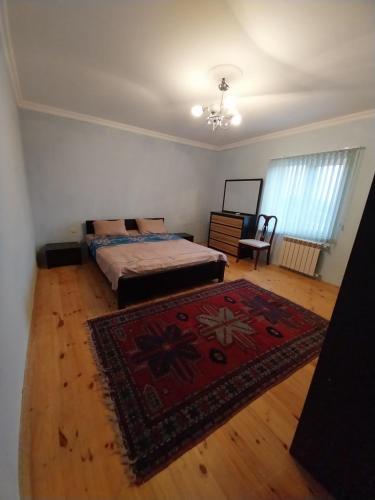 a bedroom with two beds and a rug at LALE VILLA in Baku