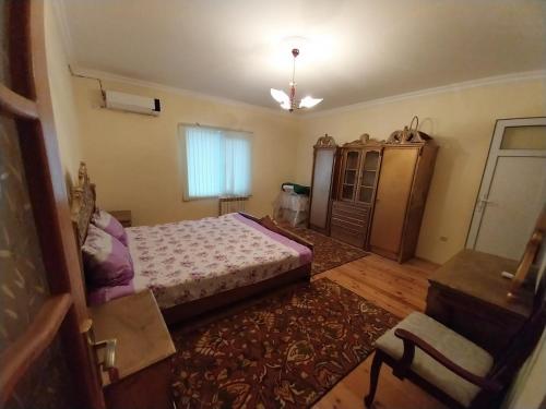 a bedroom with a bed and a dresser in it at LALE VILLA in Baku