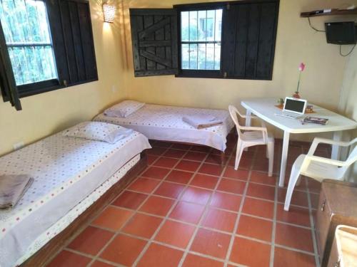 Habitación con 2 camas y mesa con ordenador portátil. en El Yaque Ranch en El Yaque