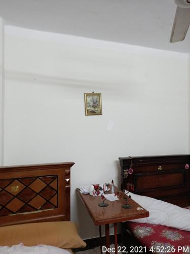 een slaapkamer met 2 bedden en een tafel. bij سوهاج الجديدة 