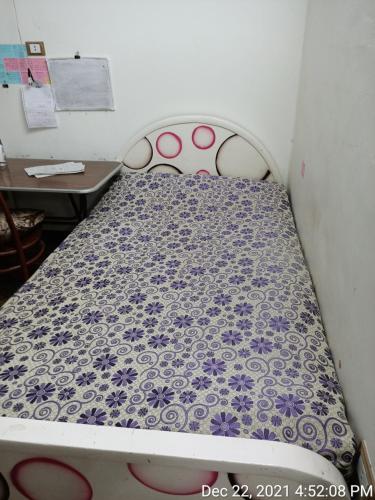 łóżko z fioletowo-białym wzorzystym materacem w obiekcie سوهاج الجديدة 
