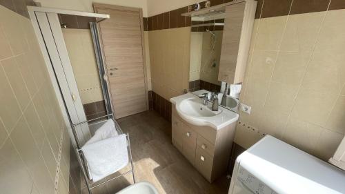 ein Badezimmer mit einem Waschbecken, einem WC und einem Spiegel in der Unterkunft Lux Kuoni Grace - Appartamento a due passi dal porto in Civitavecchia