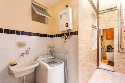 y baño con lavadora y lavamanos. en Quarto em casa de vila em Botafogo, Rio de Janeiro, en Río de Janeiro