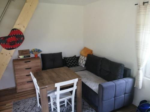 ein Wohnzimmer mit einem Sofa und einem Tisch in der Unterkunft Zelena livada (Green Meadow) in Bijelo Polje