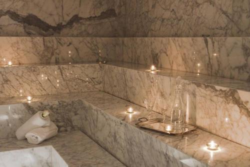 un baño de mármol con lavabo y velas. en Divino apartamento en edificio de lujo en Punta del este en Punta del Este