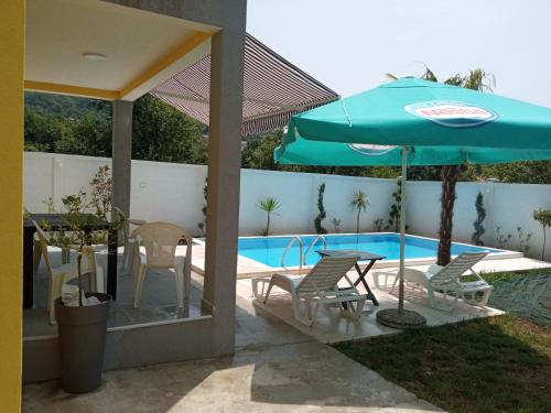 un patio con mesa, sillas y sombrilla en House with pool - Mitrovic en Herceg-Novi