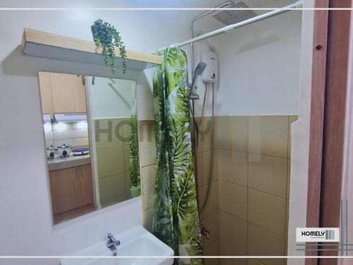 y baño con ducha, lavabo y espejo. en Homely - SMDC Green 2 Residences, Dasmarinas City en Pasong Bayog