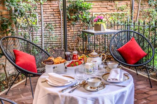 a table with a white table cloth with food on it at Mangili Garden Hotel in Rome