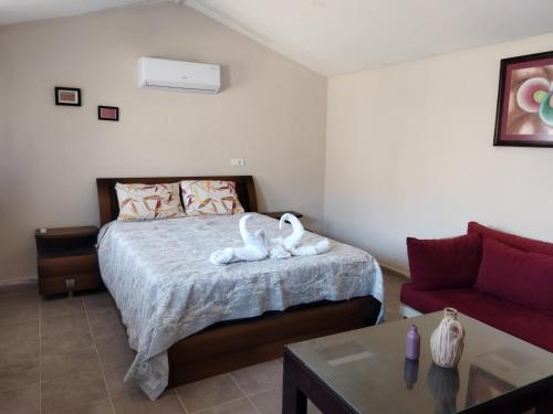 ein Schlafzimmer mit einem Bett mit zwei Schwänen darauf in der Unterkunft Pavlonya Bungalows in Muğla
