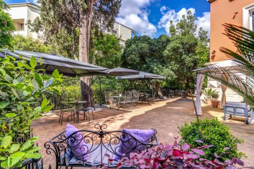 a patio with chairs and tables and umbrellas at Mangili Garden Hotel in Rome