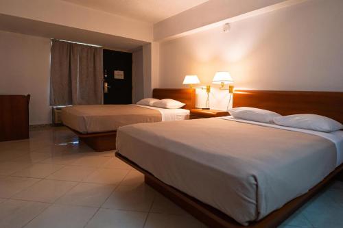 a hotel room with two beds and two lamps at Solace by the Sea in Ponce