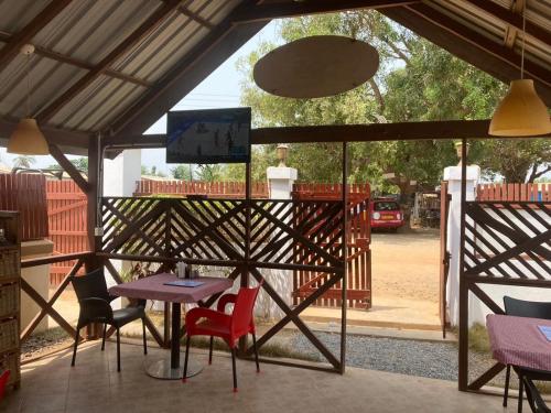 a patio with a table and chairs and a screen at Ezime Guesthouse And Pizzeria in Ada