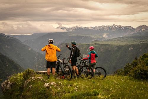 three people standing on top of a hill with bikes at Grab cabin in Pluzine
