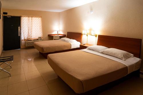 a hotel room with two beds and a window at Solace by the Sea in Ponce