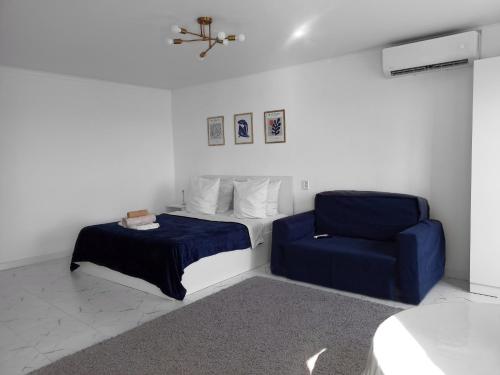 una camera con letto e sedia blu di Shugyla 1 Room a Kooperator
