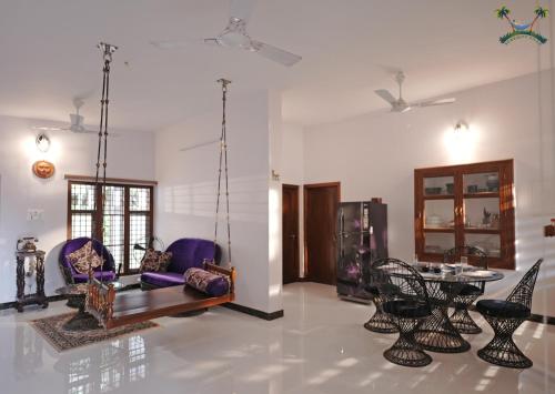 uma sala de estar com cadeiras e uma mesa em Serenity Villa and Treehouse em Palakkad