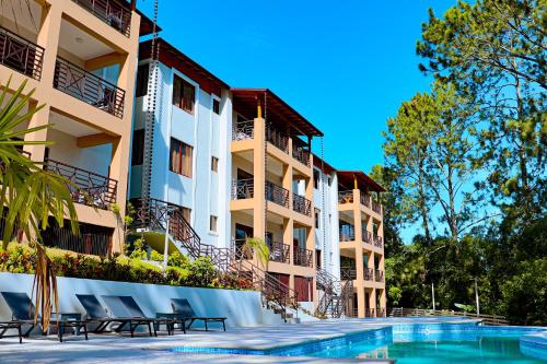 ein Hotel mit einem Pool vor einem Gebäude in der Unterkunft Vista del Campo Country Club & Villas in Jarabacoa