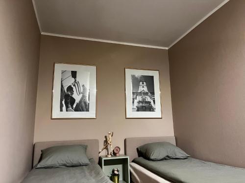 sypialnia z 2 łóżkami i 2 zdjęciami na ścianie w obiekcie Jourek Apartment w mieście Varaždin