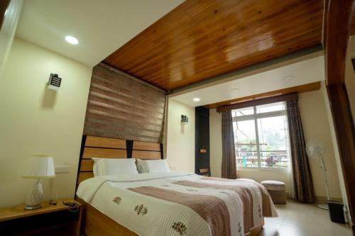 a bedroom with a large bed and a window at East Land Bed & Breakfast in Shillong