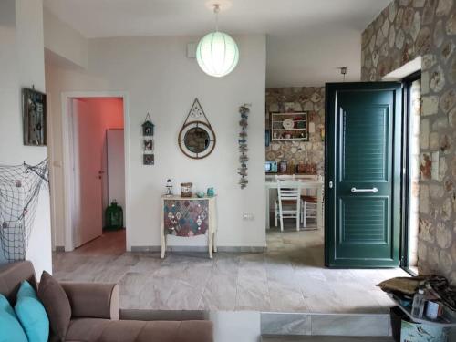 una sala de estar con una puerta verde y una mesa en Korina's house, en Loutsa