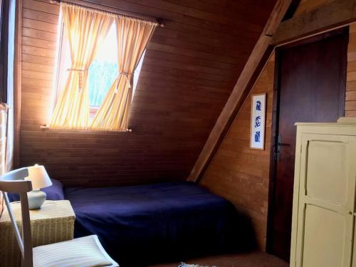 een slaapkamer met een blauw bed en een raam bij Maison Médiévale in Dinan