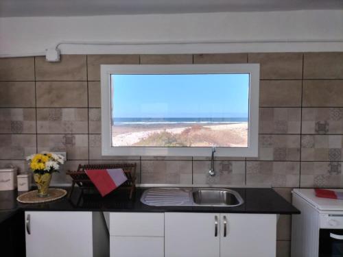 a kitchen with a sink and a view of the beach at Vista Paraiso, Sea breeze facing the sea in La Oliva