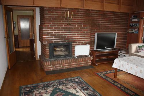 a living room with a brick fireplace and a tv at 14 B in Stavanger