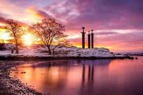 a winter sunset with snow on a small island in the water at 14 B in Stavanger