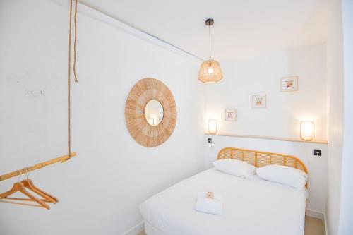 une chambre blanche avec un lit et un miroir dans l'établissement Appart 2 ch clim proche Vieux-Port Gare St-Charles, à Marseille