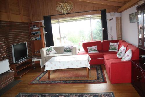 a living room with a red couch and a tv at 14 B in Stavanger