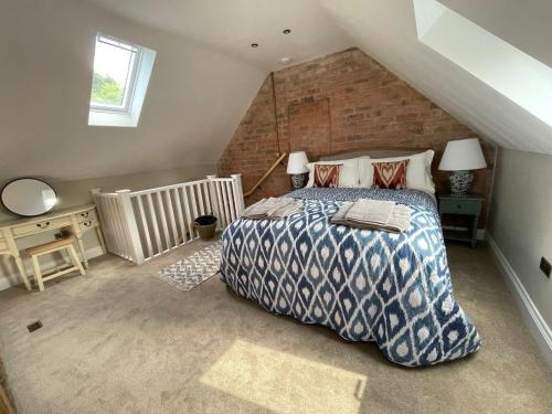 a bedroom with a bed and a brick wall at Converted Bullamoor Barns, Northallerton in Northallerton