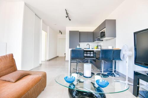 een woonkamer met een bank en een glazen tafel bij Le Ruffi - Appart 1 ch avec terrasse et parking in Marseille