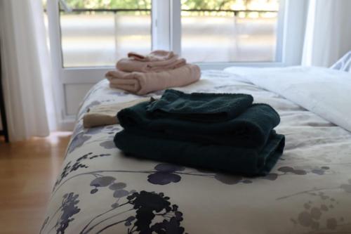 a pile of towels sitting on top of a bed at Comme sur un nuage, appartement pour 4 personnes in Nendaz
