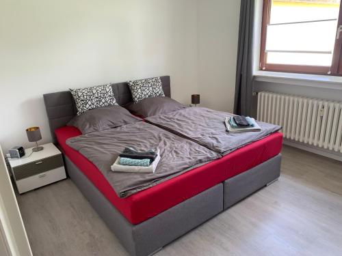 a bed with a red bed frame in a room at FeldQuartier in Grebenstein