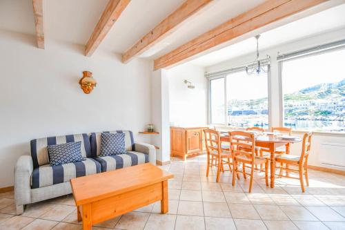 a living room with a couch and a table and chairs at Le Cabanon des Goudes - Vue mer et parking in Marseille