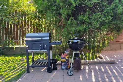 a bbq and a grill sitting on a patio at Flóra House 3 minutes from Lake Balaton in Keszthely