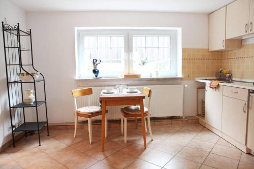 Schöne Wohnung für einen Kurzurlaub in Lüneburg في لونبورغ: مطبخ مع طاولة وكراسي ونافذة